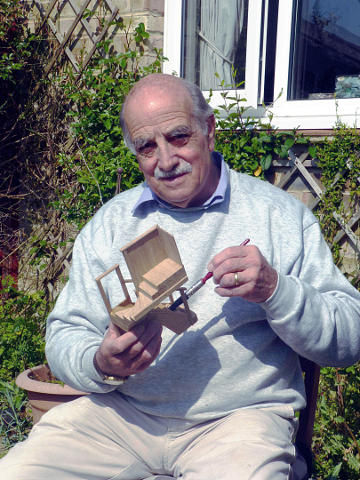 Photograph of Paul varnishing the model of the new stairs to the gallery